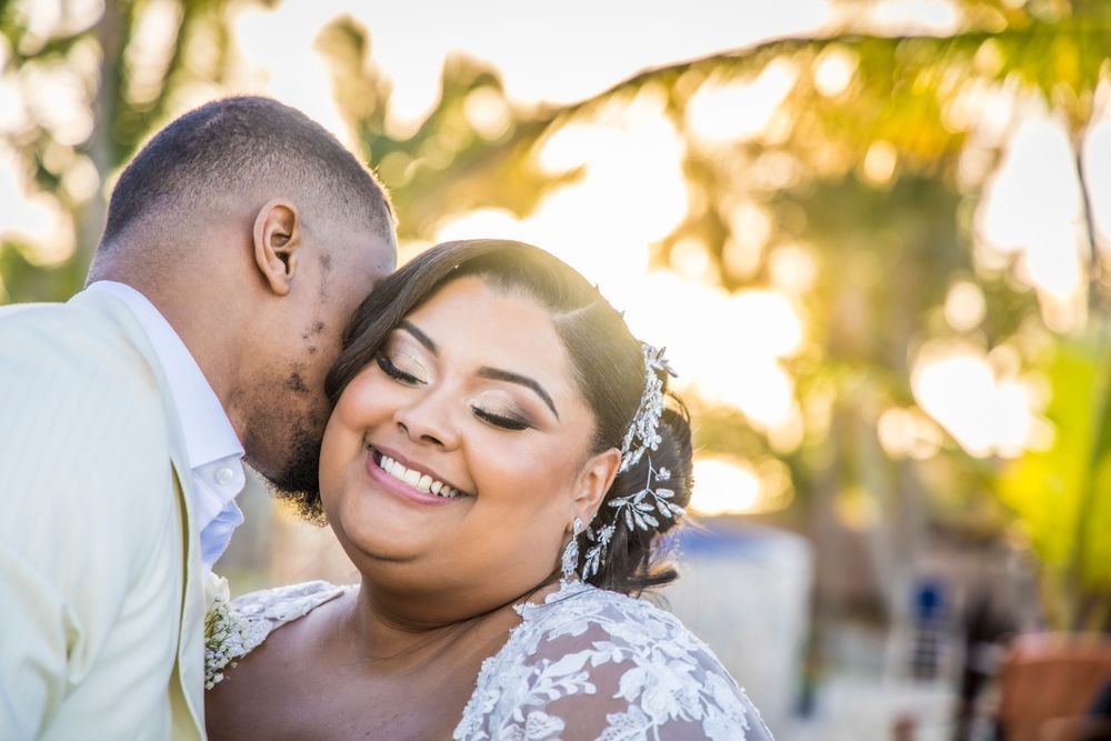 An intimate wedding portrait captured during golden hour with palm trees in the background.