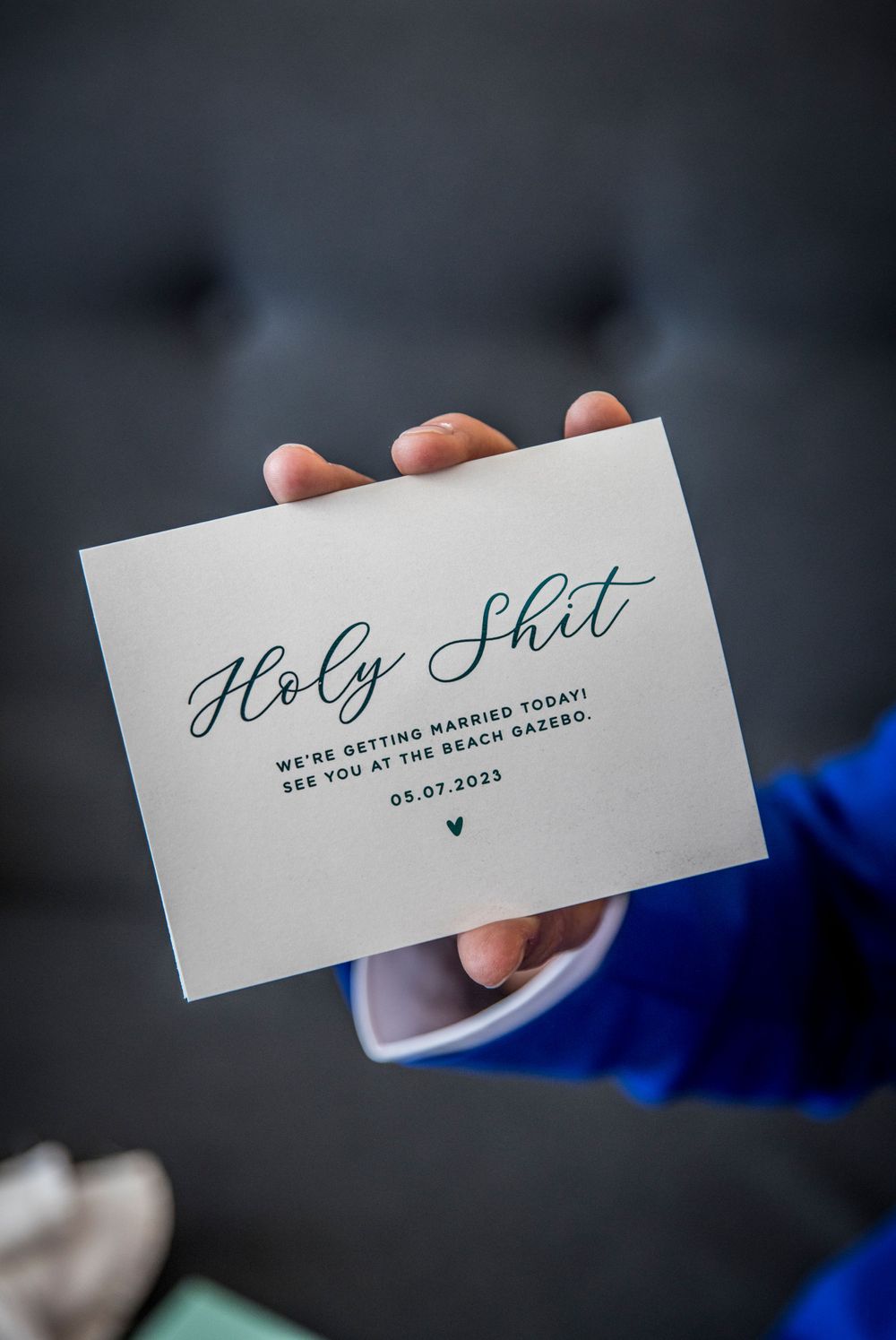 Elegant calligraphy wedding invitation card displayed against dark background with blue accent.