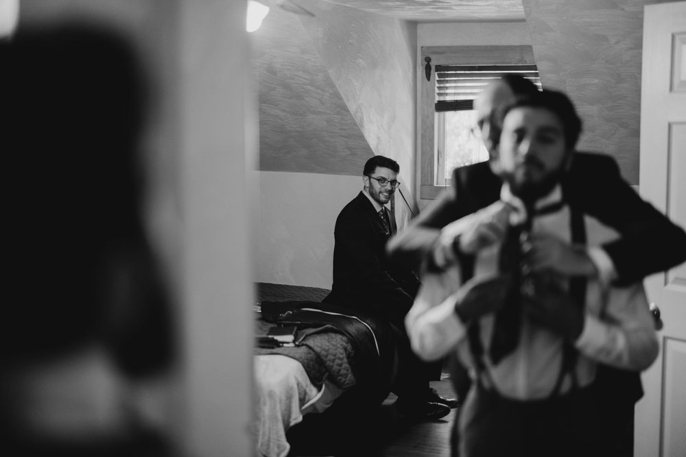 Black and white candid shots of wedding party getting ready in indoor venue.
