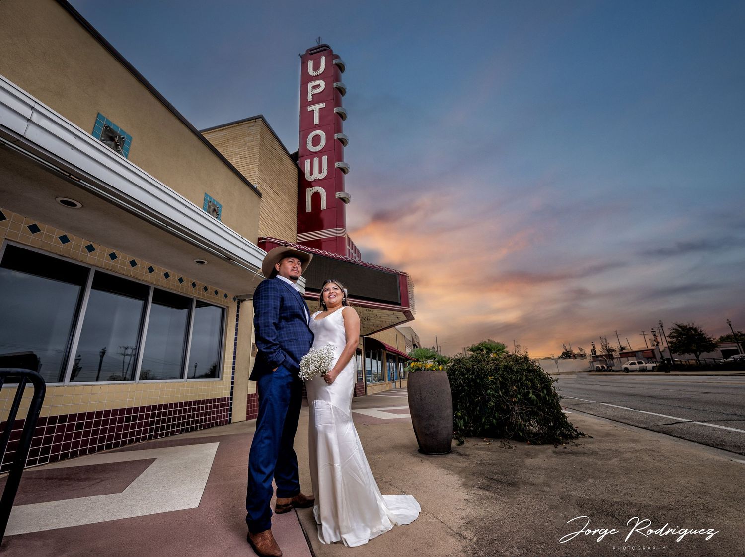 wedding couple posing for an incredible photo with magestic sunset.