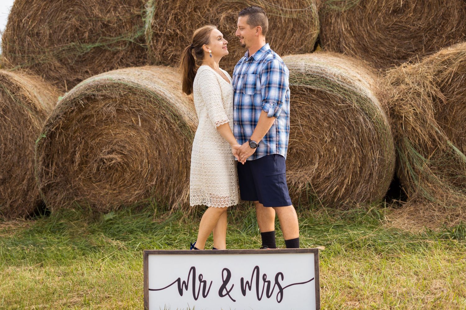 A couple in front of a hay wall
