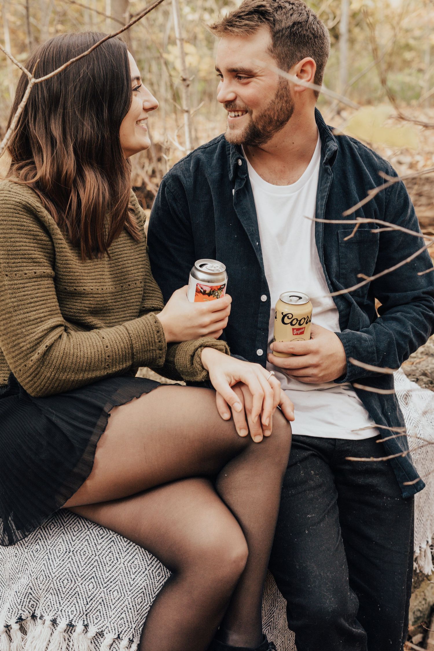 Image of woman and man drinking beer and smiling together in forest.