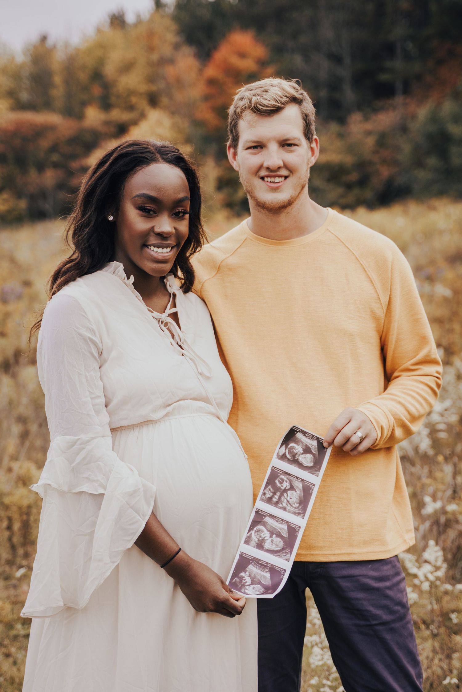 Image of woman and man holding up ultrasound photos.