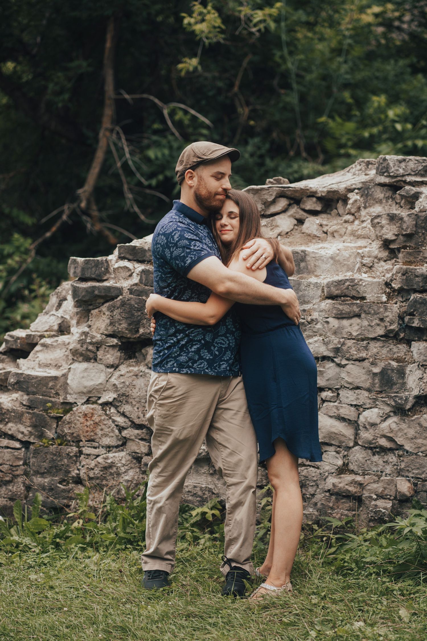 Image of woman and man hugging in front of rock wall.