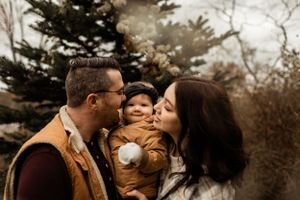 An intimate family moment captured outdoors during a cool autumn day.