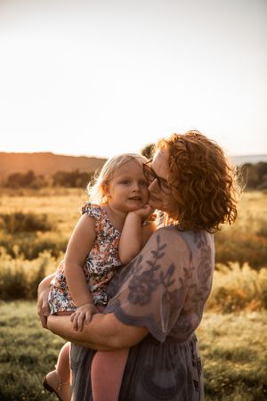 A tender moment between parent and child at sunset in a golden field.