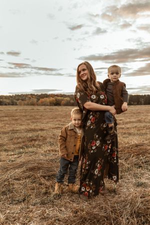 A heartwarming autumn family moment captured in a golden field at sunset.