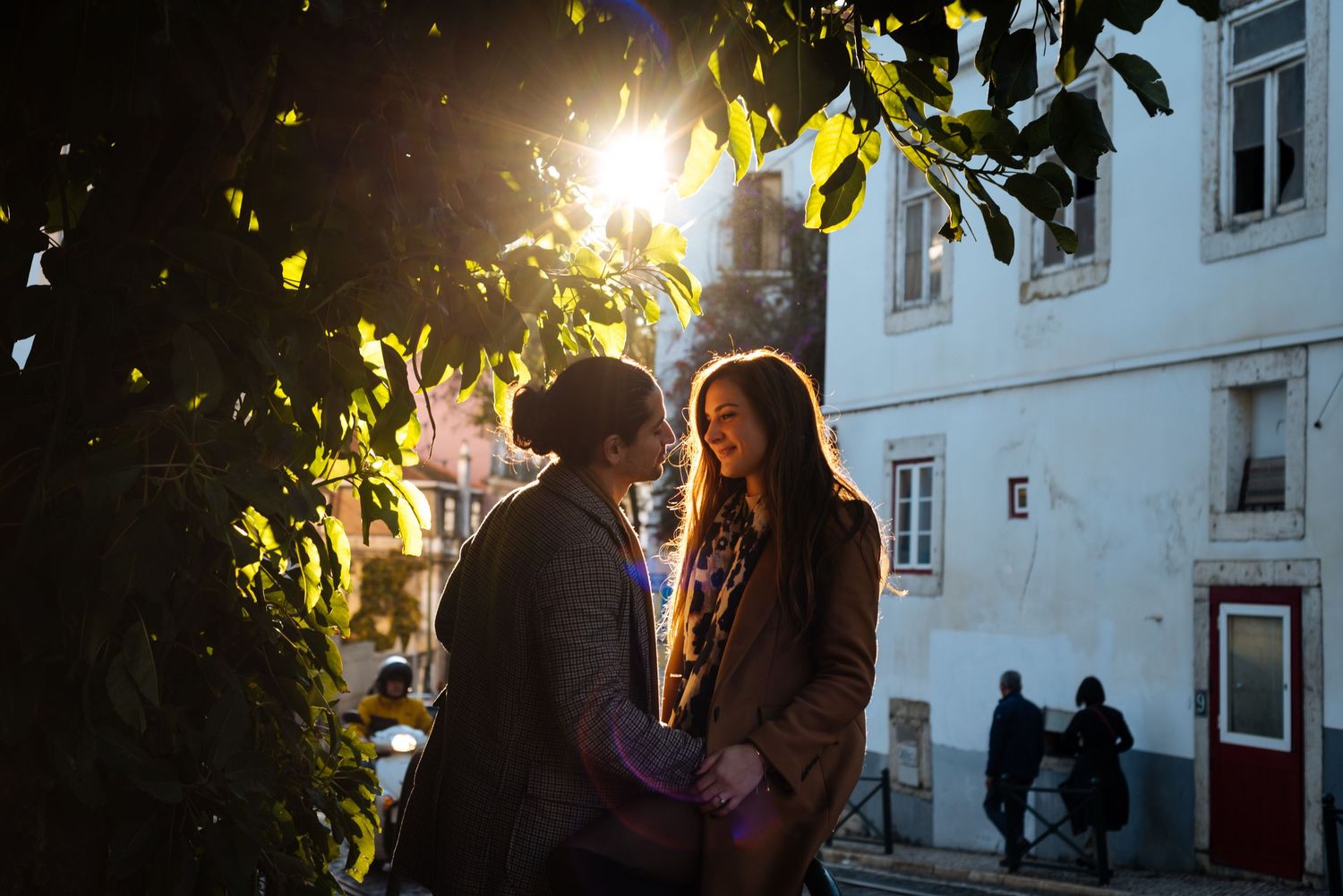 couple flirting iluminated with sunset backlight at a engagement photoshoot in Lisbon