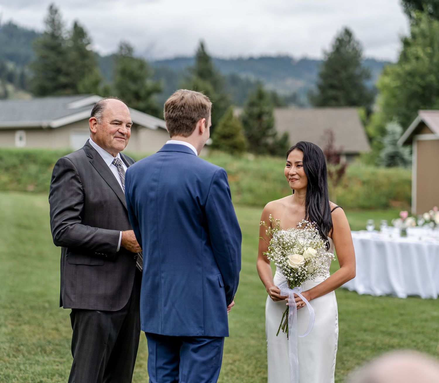 An intimate outdoor wedding ceremony moment on a scenic hillside with mountain views.