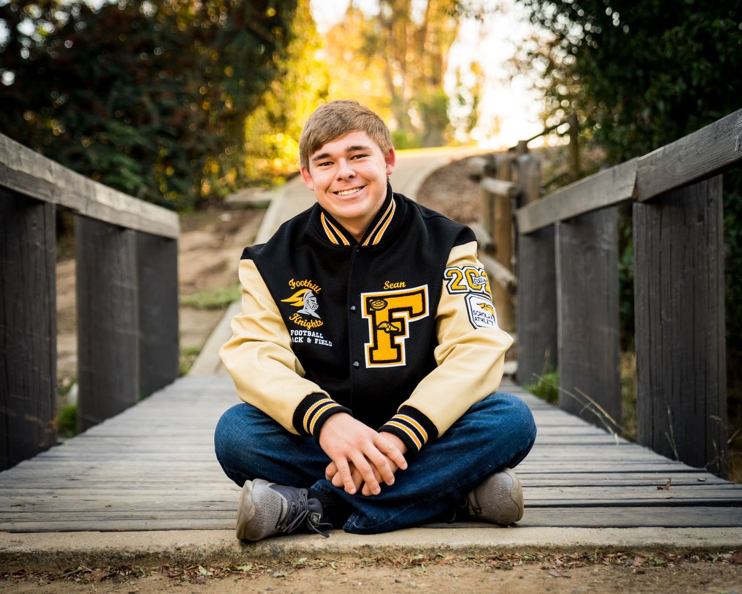 High-School-Senior-boy-with-letterman's-jacket-posing-for-senior-pictures