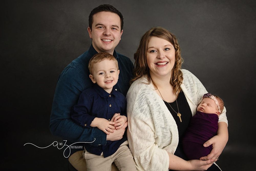 Studio family portrait against dark background.