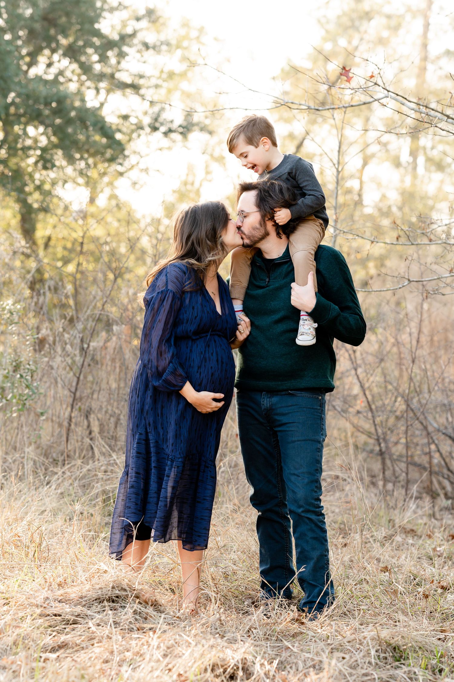 Intimate family portrait session captured at sunset in a rustic outdoor setting.