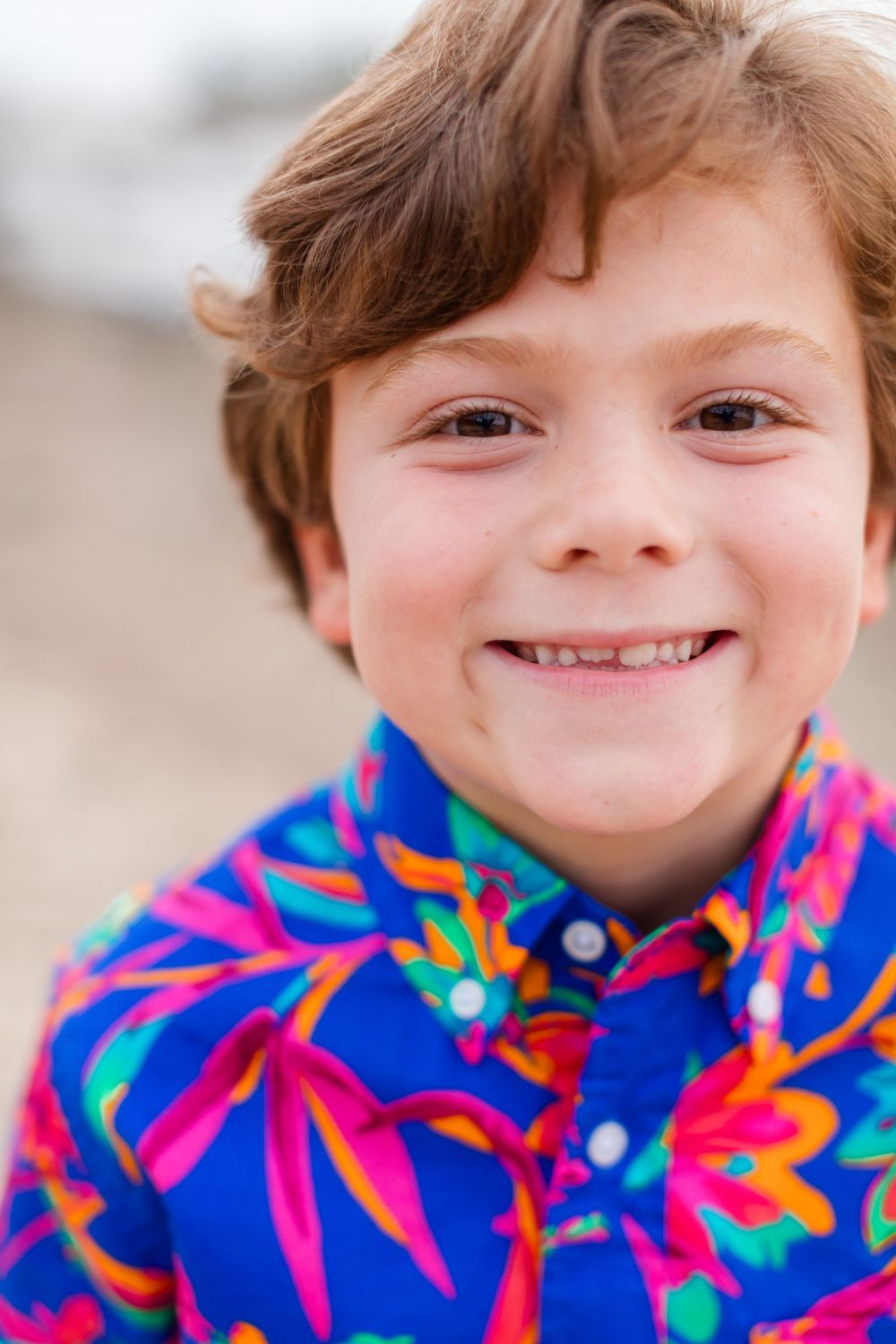 Close up portrait of a child wearing a colorful tropical print shirt.