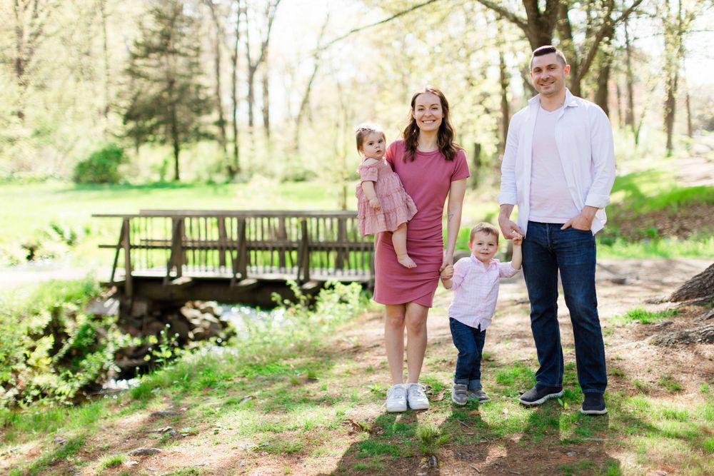 Family walking together outdoors on a sunny spring day in a park setting.
