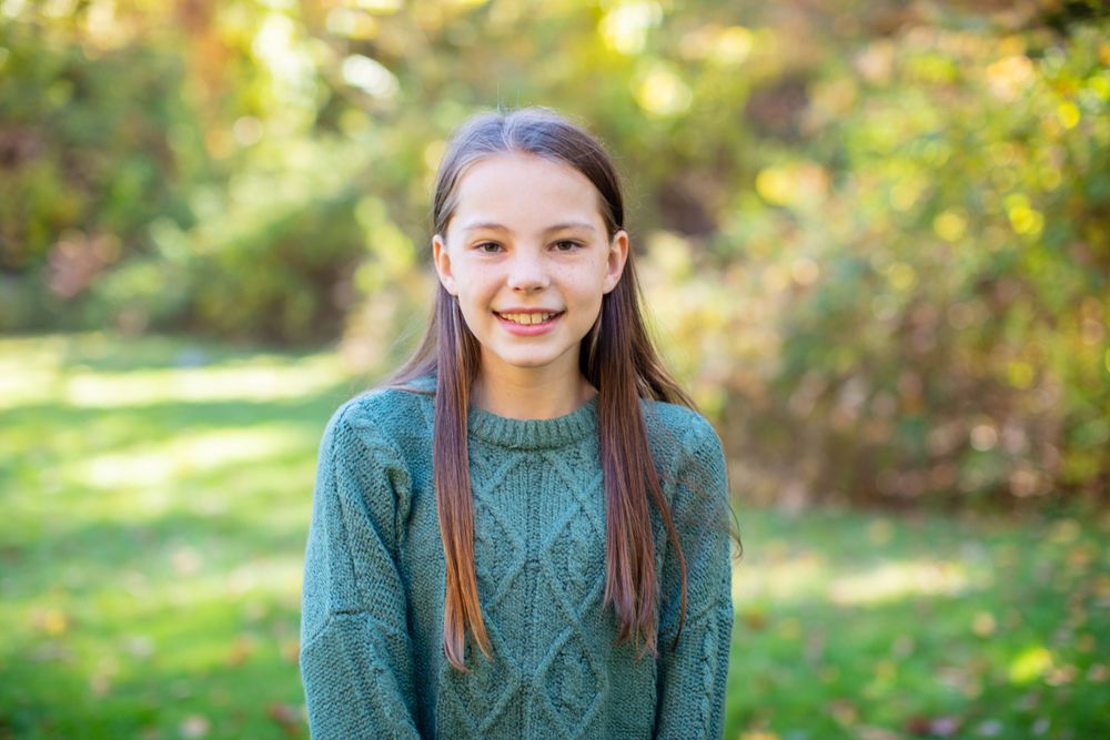Portrait session in a natural setting with autumn colors in the background.