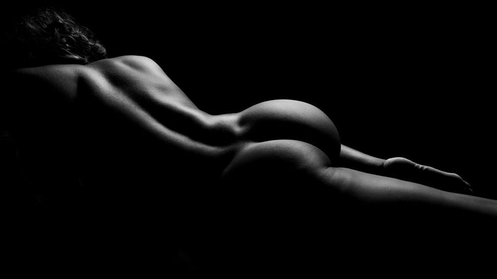 Minimalist black and white study of human form with gentle curves and shadows.