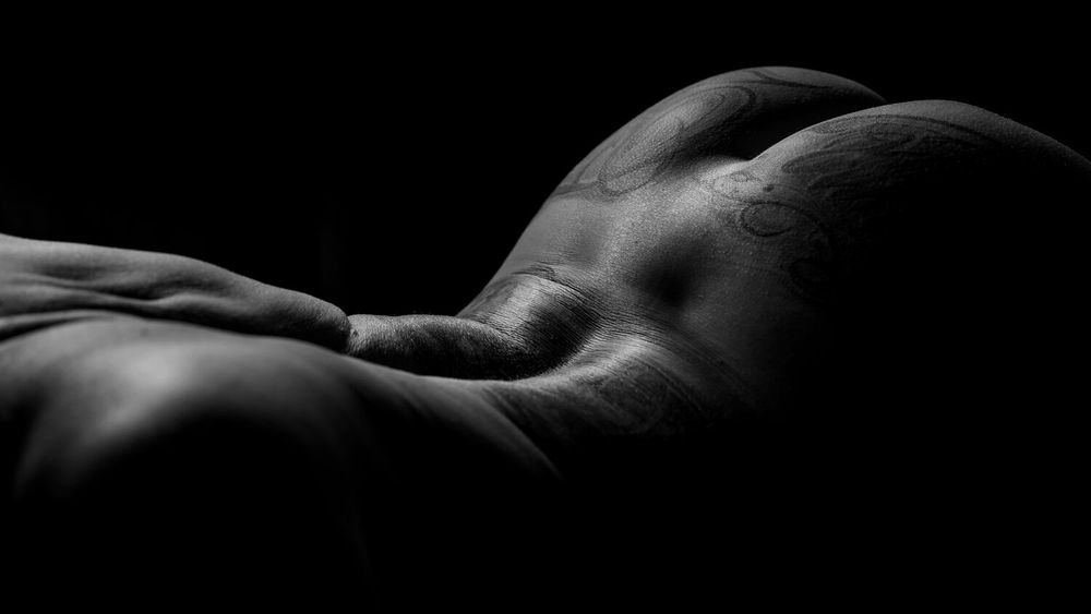 Abstract bodyscape photography highlighting natural curves in dramatic black and white contrast.