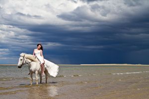 women riding a horse in the sea