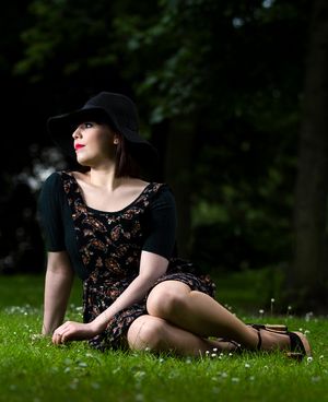 lady under a tree wearing a black cap