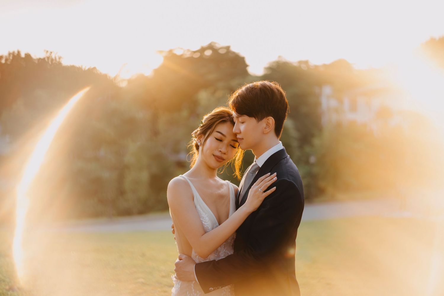 A romantic sunset embrace between newlyweds with golden light creating a dreamy atmosphere.
