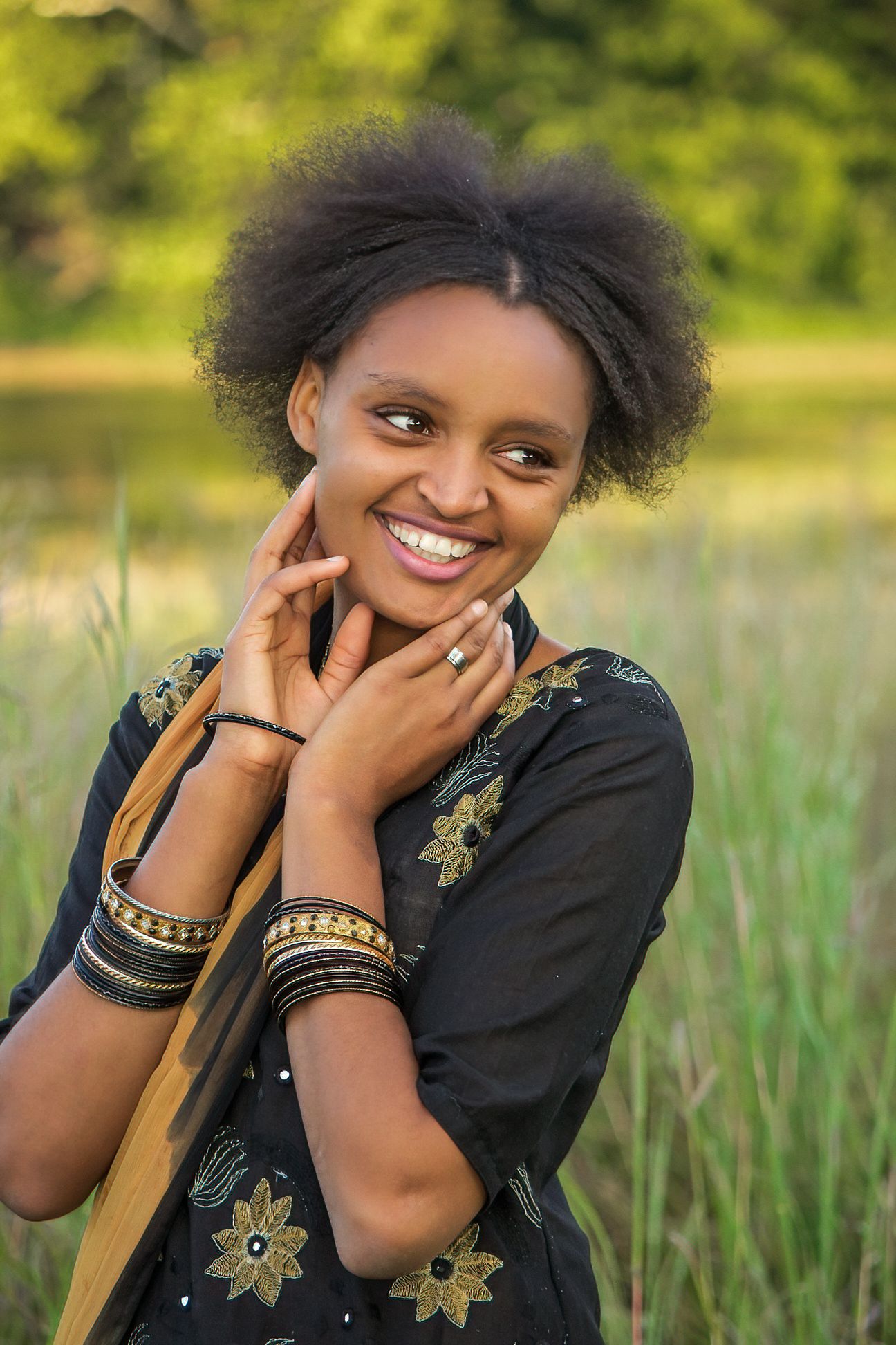 woman in traditional Ethiopian dress smiles off camera