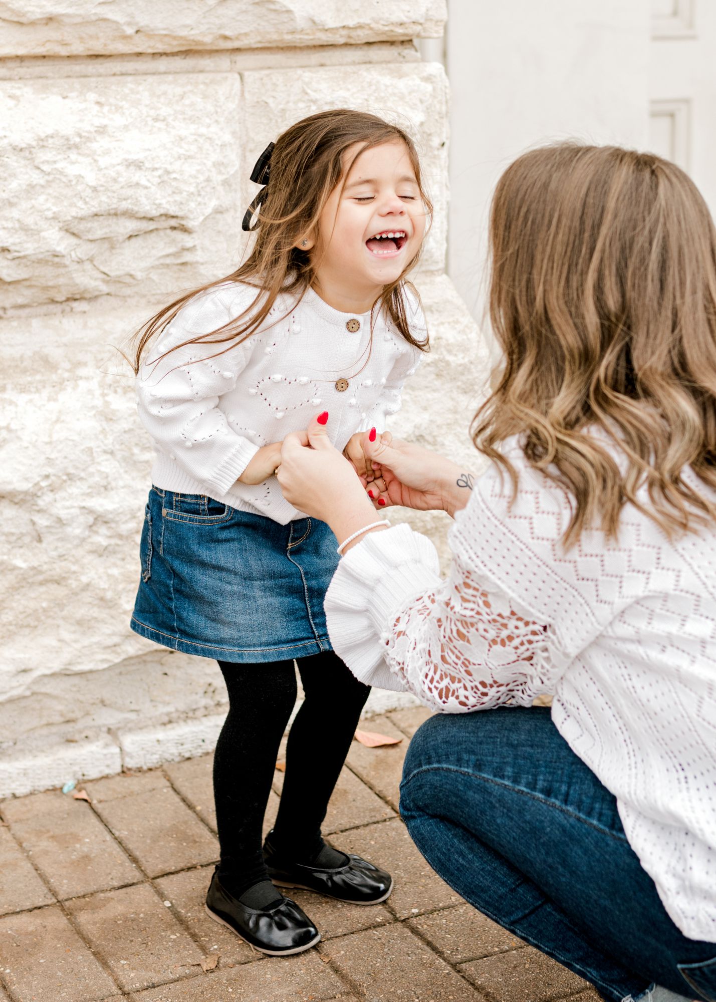 Joyful laughter shared during interactive moment against stone wall background.
