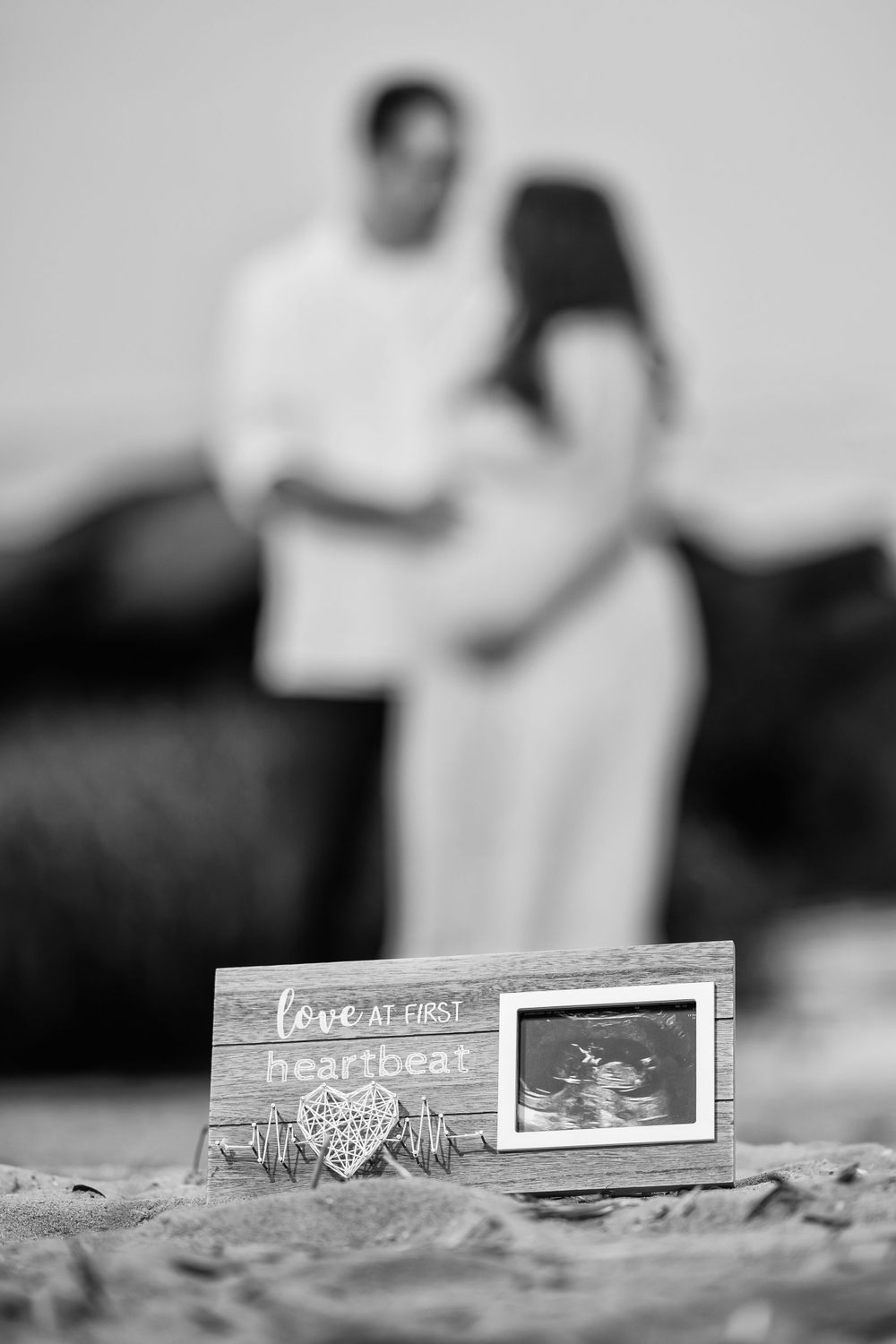 Artistic black and white photo of wooden signs against blurred romantic background.