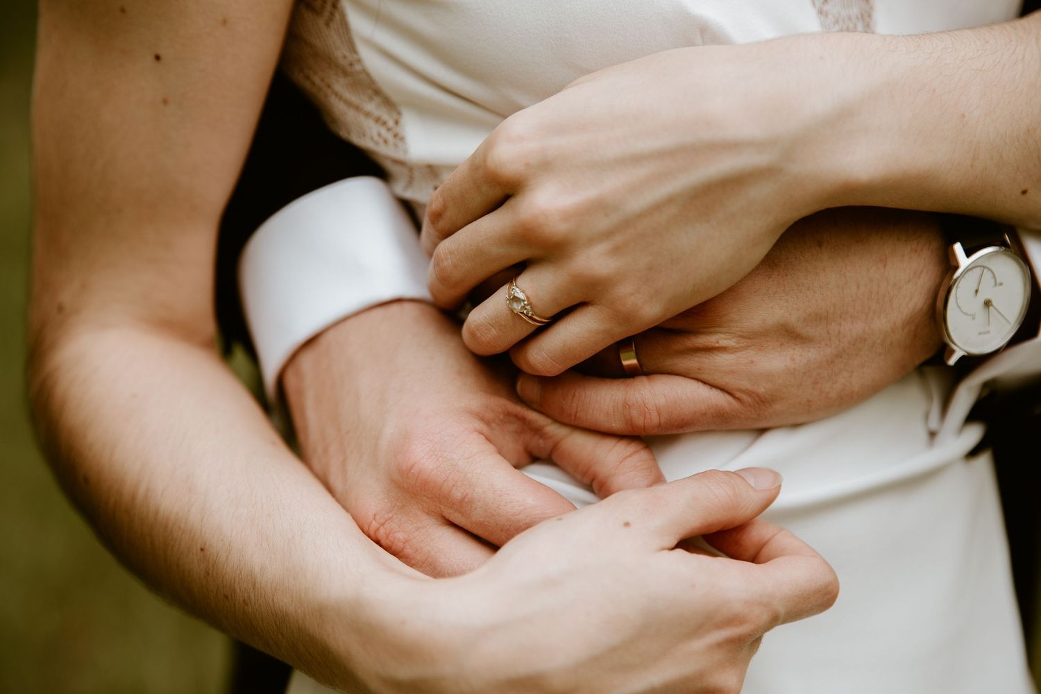 vintage looking wedding photo of bride and groom's hands caressing each other