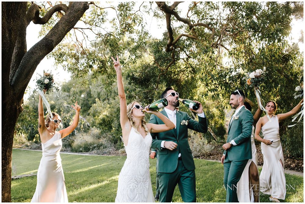 Bride and groom and bridal party celebrating after opening the champagne
