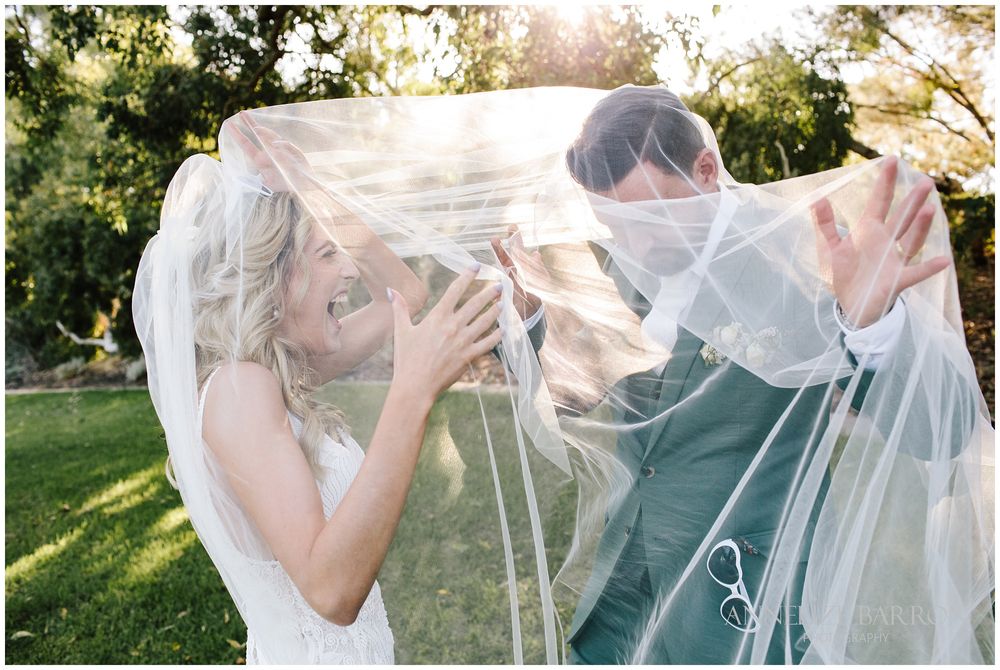 Bride and groom playing under the veil
