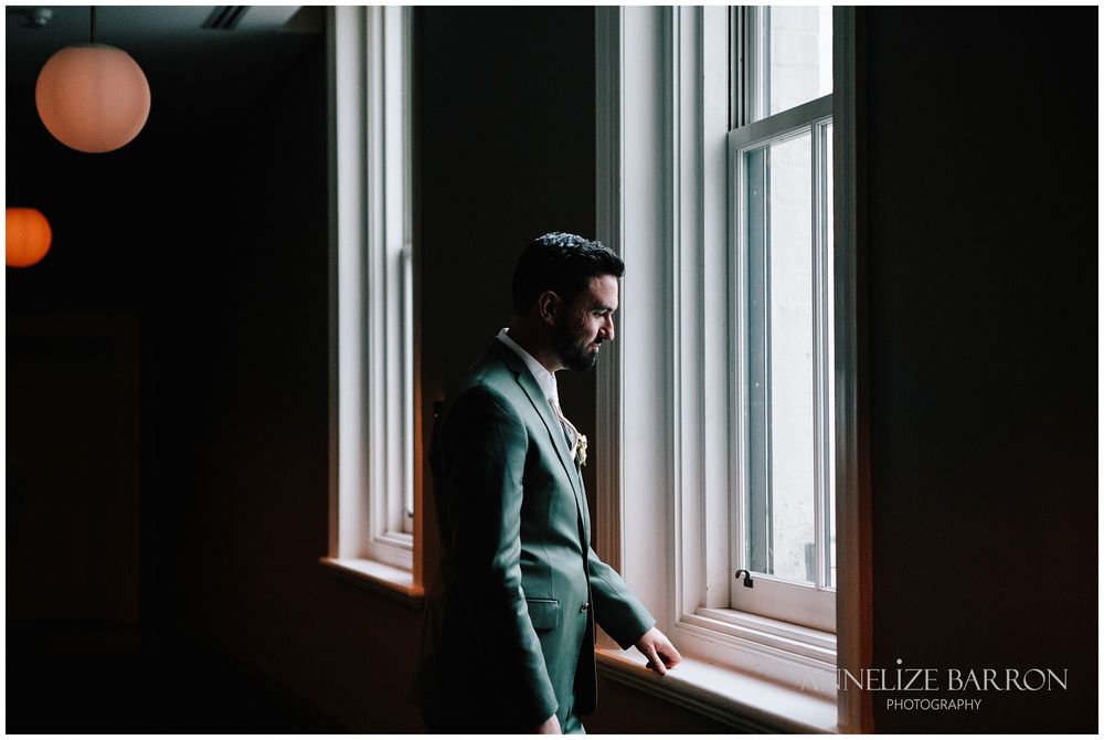 Groom looking out the window at this COMO the Treasury wedding