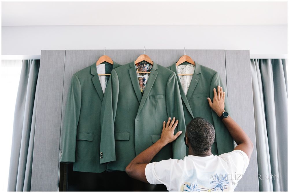 Groomsman hanging up the suit jackets