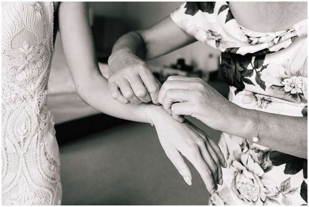mother putting a bracelet on the bride