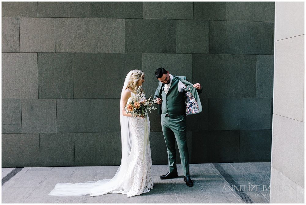Groom showing his bride his customised Suit jacket at this COMO the Treasury wedding