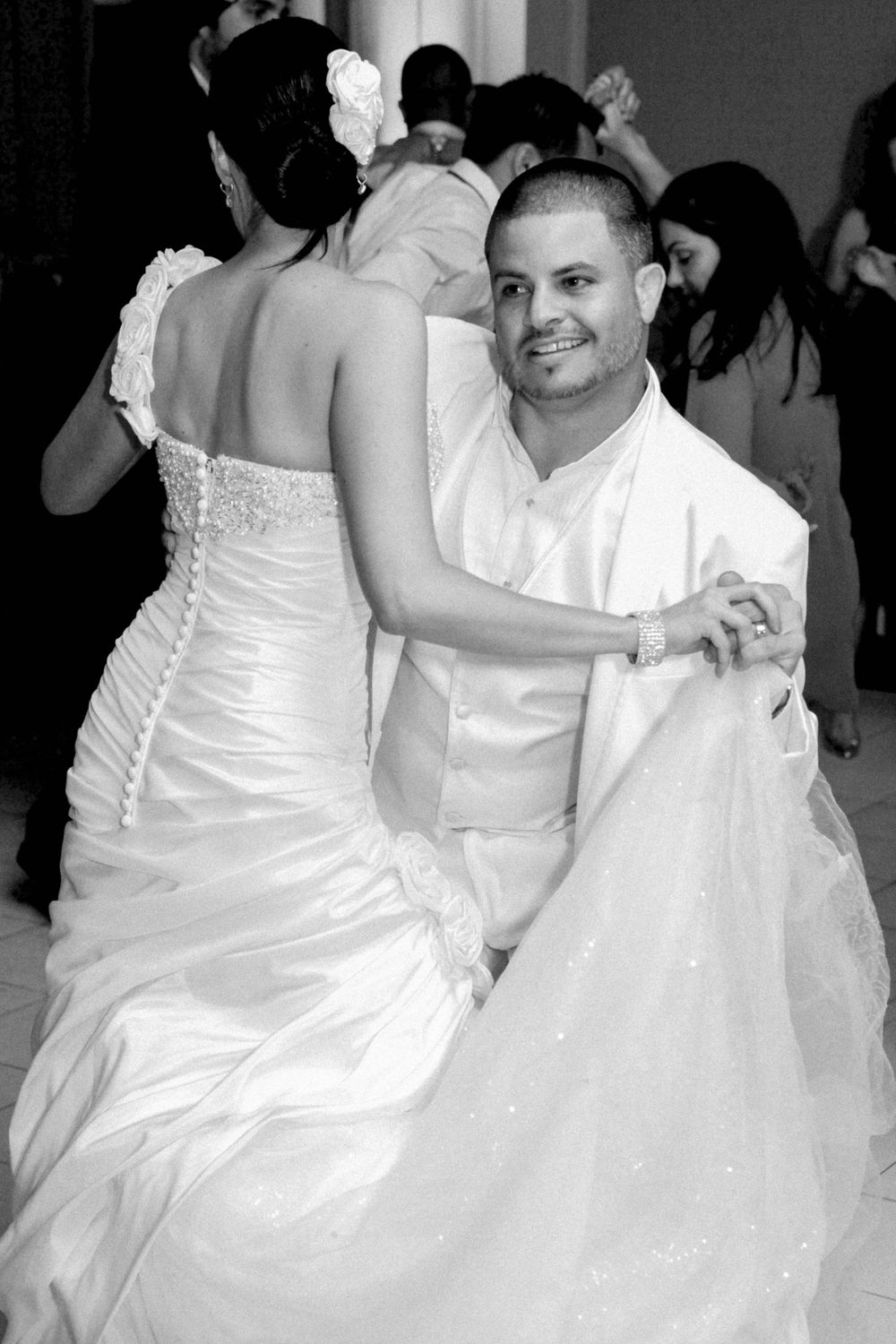 A couple shares an intimate dance at their wedding reception, with the bride wearing a white strapless gown.
