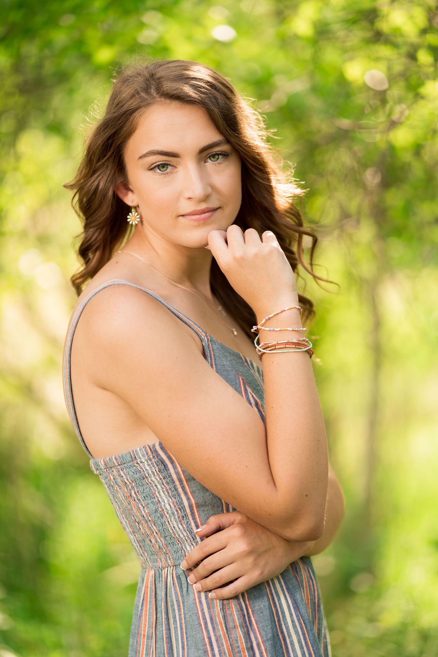 Candid summer portrait series showing playful expressions in a sunlit forest setting.