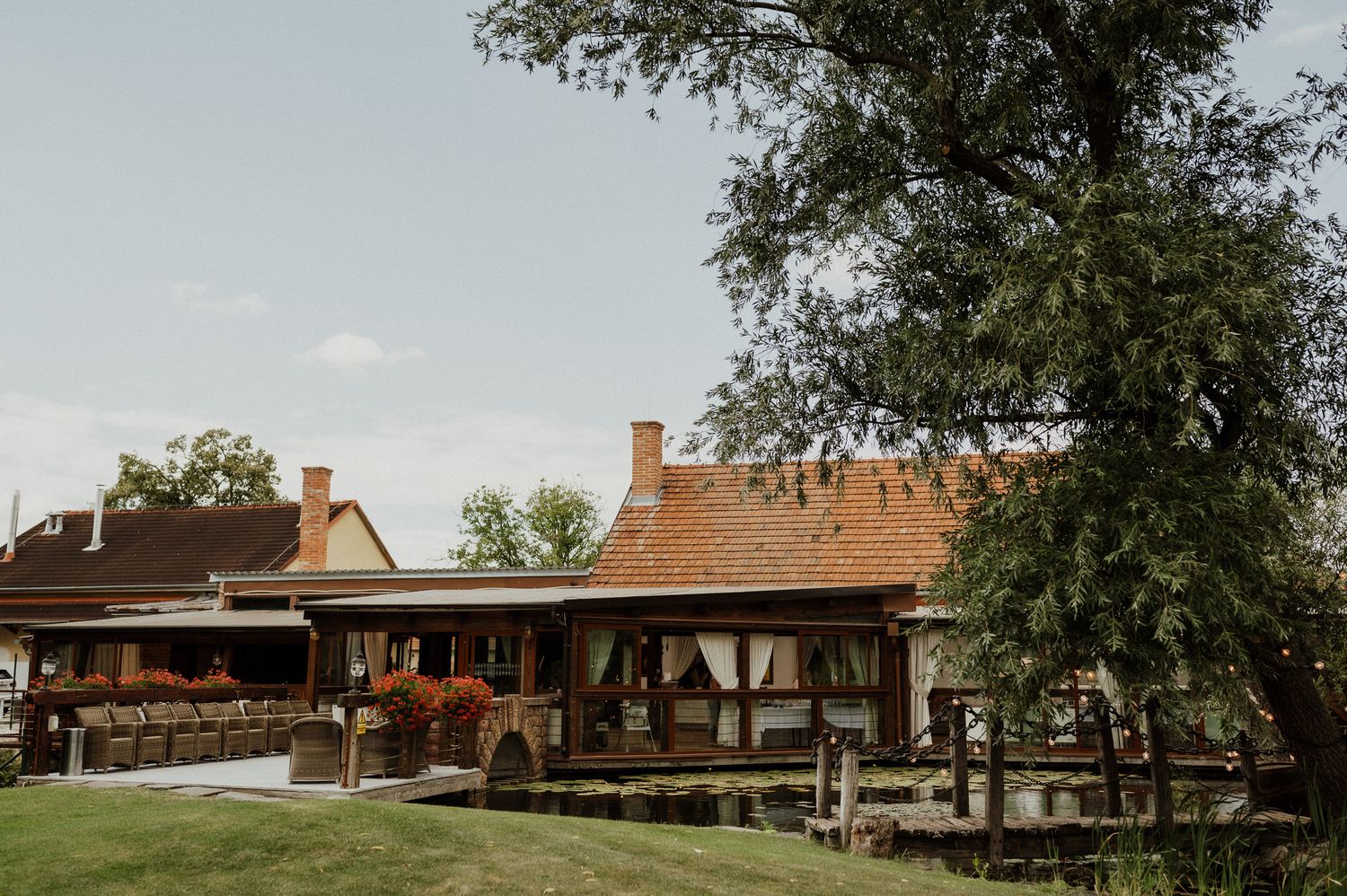 Rustic countryside venue with traditional architecture and large trees in the background.