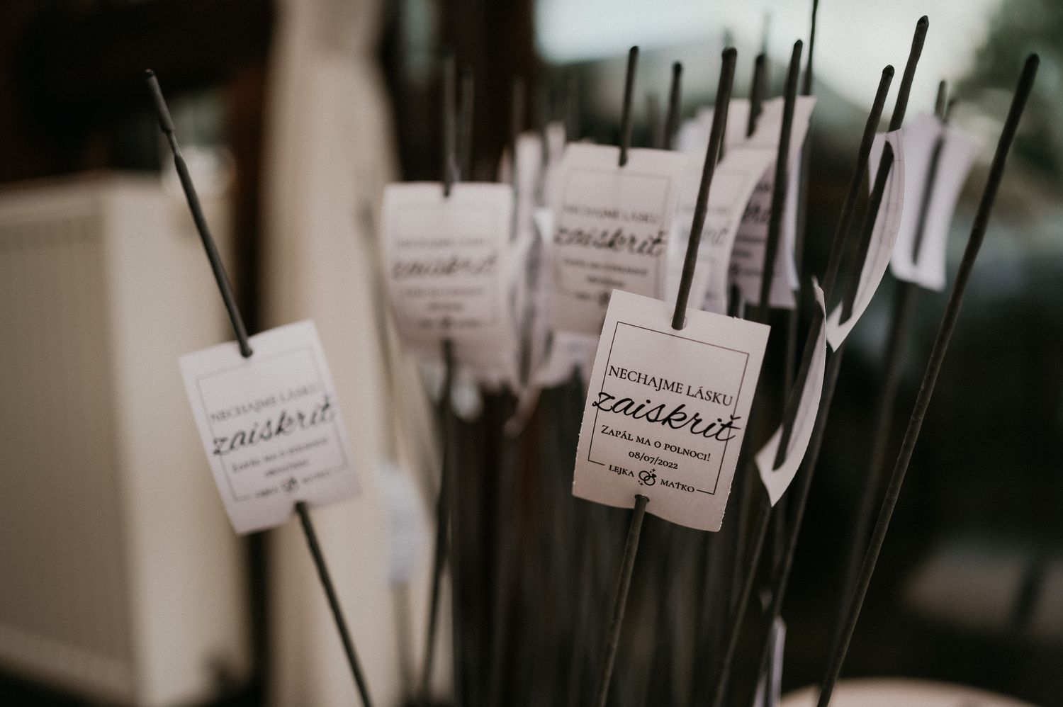 Wedding sparklers with custom labels arranged in a decorative display.