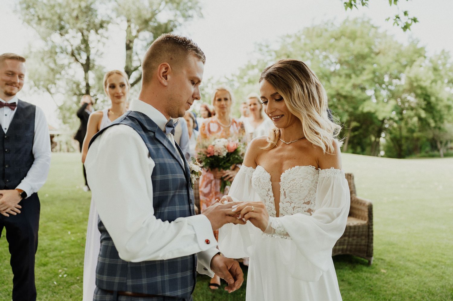 A couple shares their wedding vows during a sun-drenched outdoor ceremony.