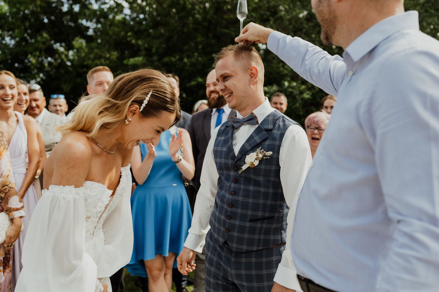 Wedding celebration moment with guests laughing during outdoor ceremony.
