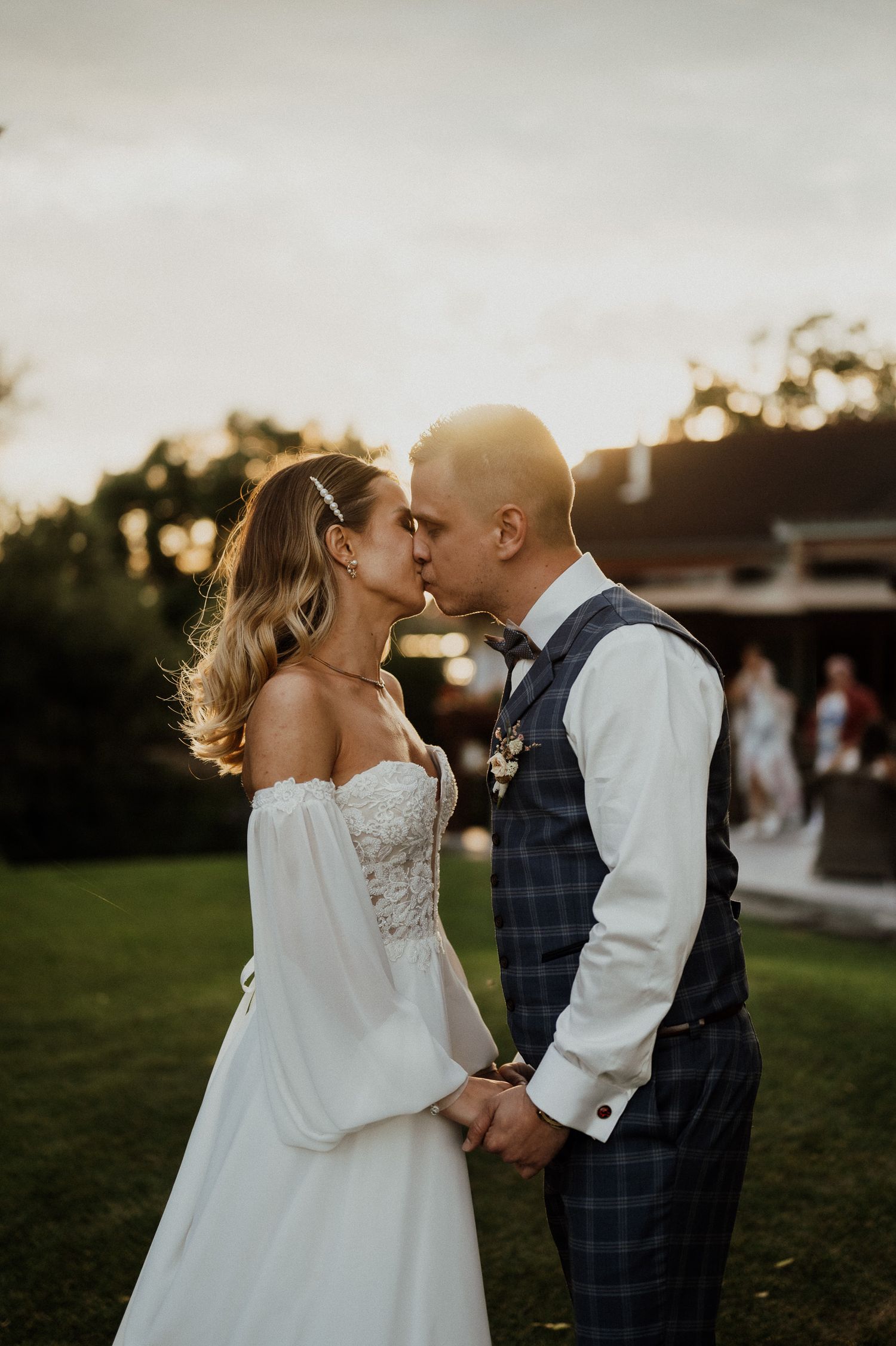 Romantic sunset wedding portrait in garden setting with soft lighting.