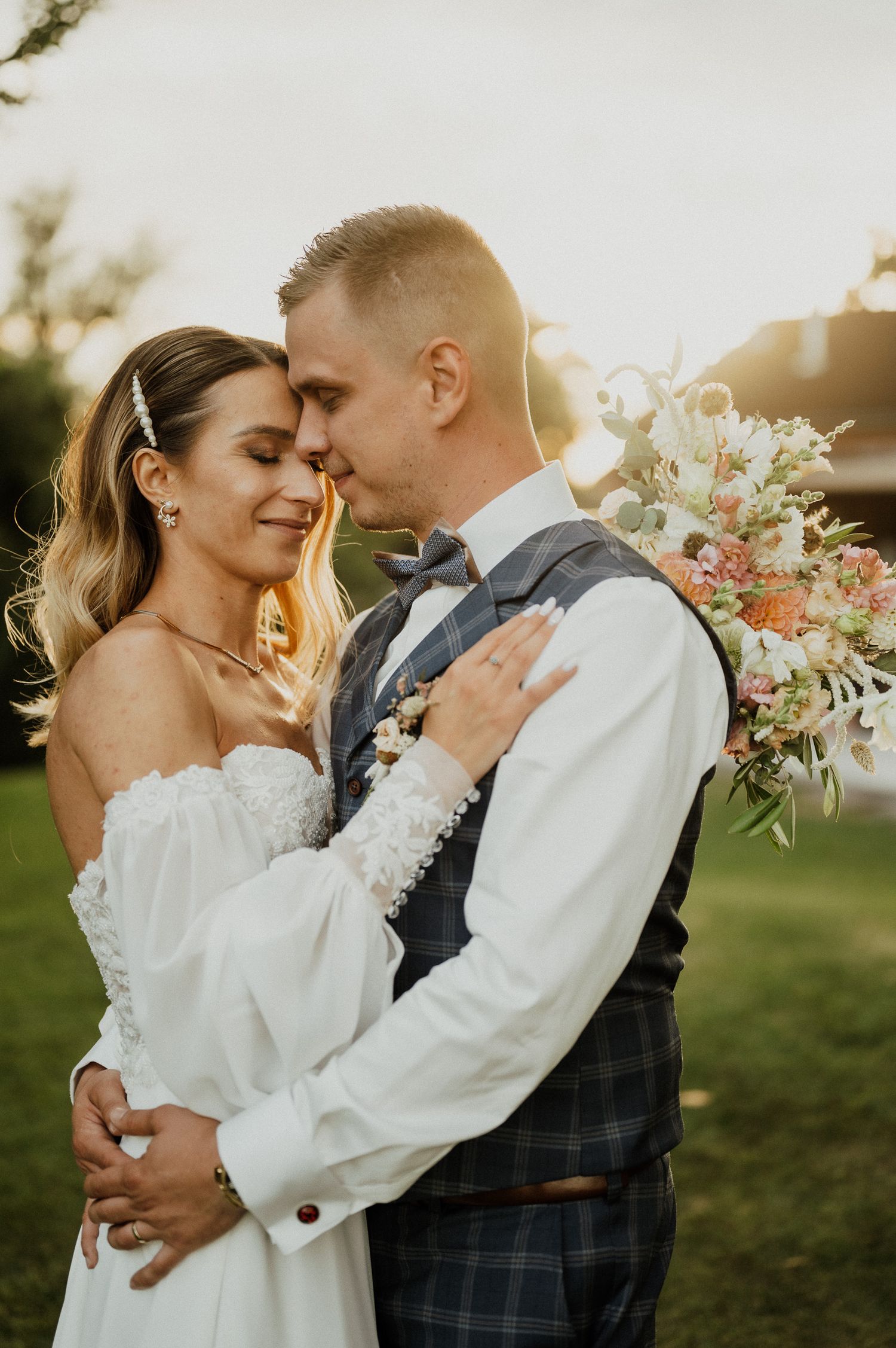 An intimate moment between newlyweds sharing a tender embrace during golden hour.