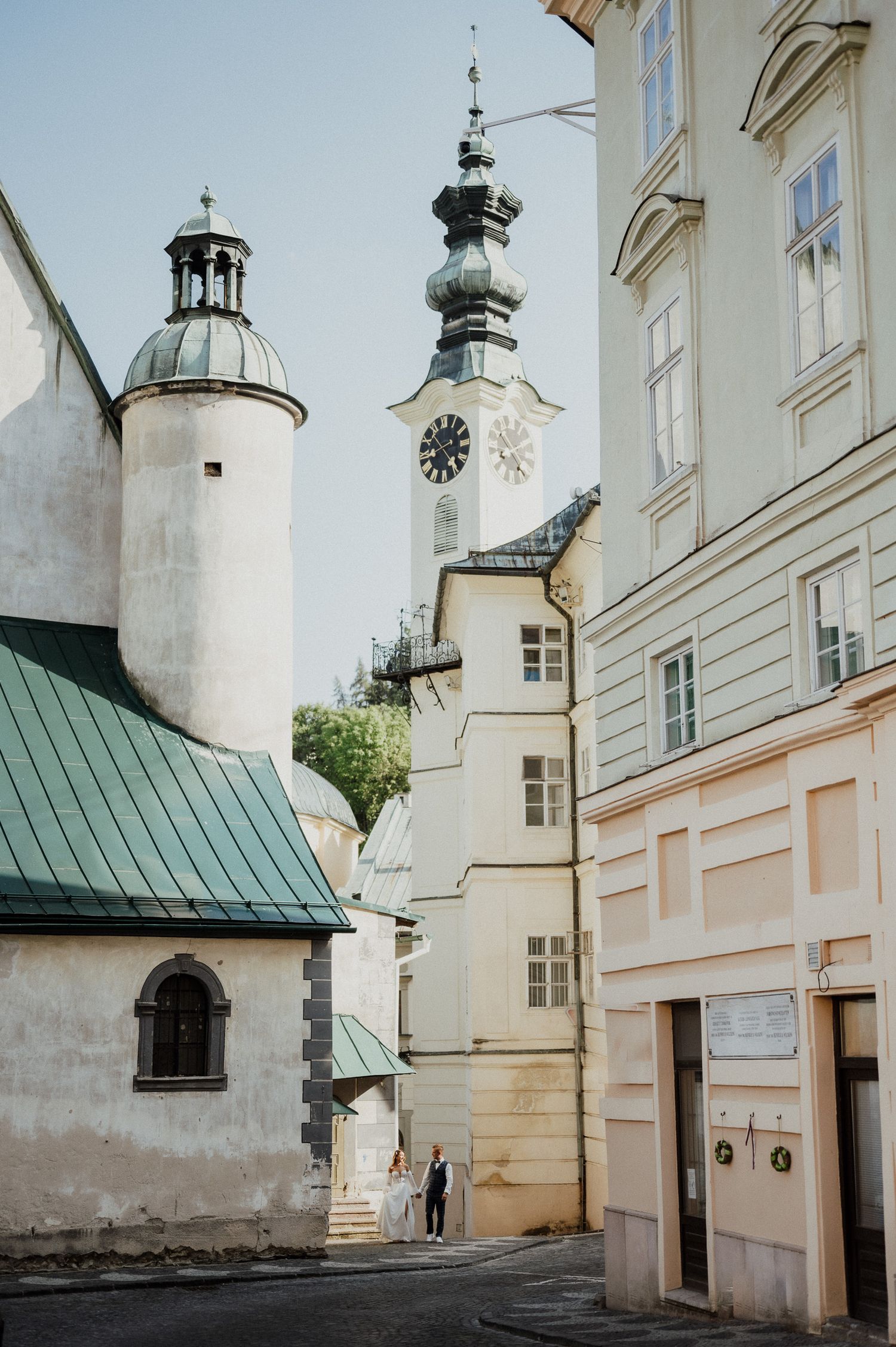 Historic European architecture with church towers and narrow alleyway.