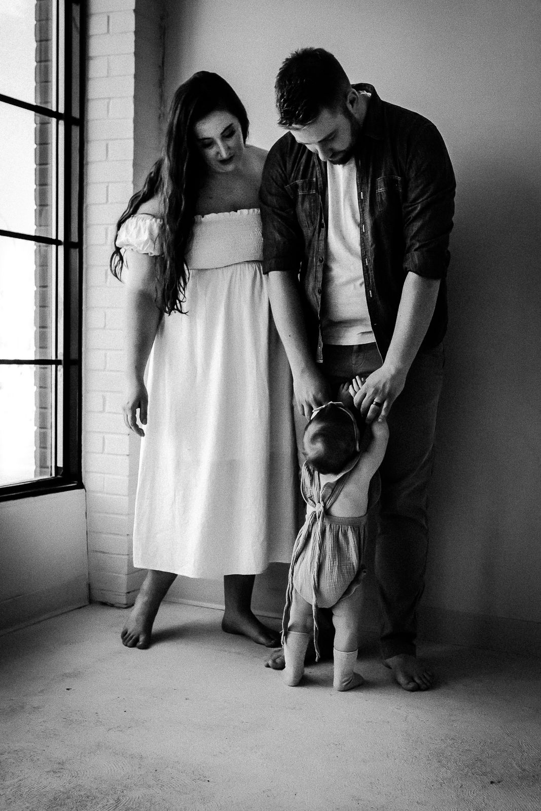 Black & white image of parents with toddler during mini session at Studio Boheme with Love & Sunshine Photography