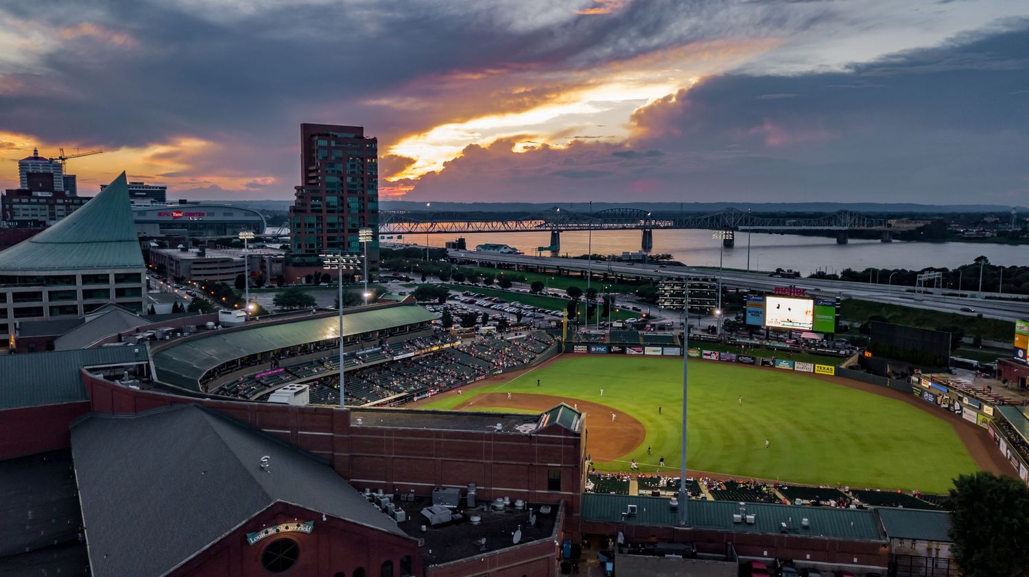 Louisville Slugger Field and waterfront area captured at sunset with dramatic sky.