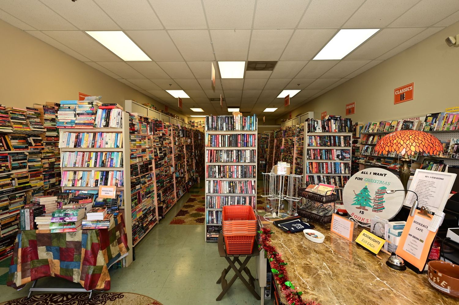 Wide angle view of used bookstore interior showing multiple aisles of packed bookshelves.