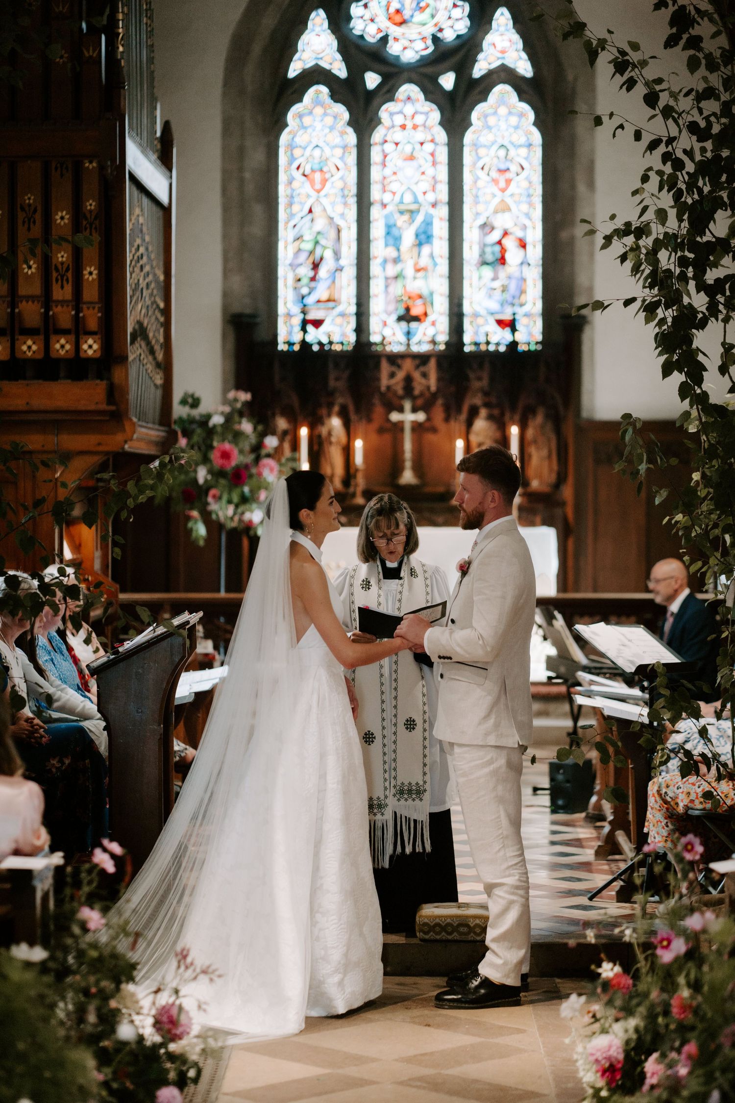 bride and groom exchanging vows at the church alter at st Nicholas church in Oxfordshire