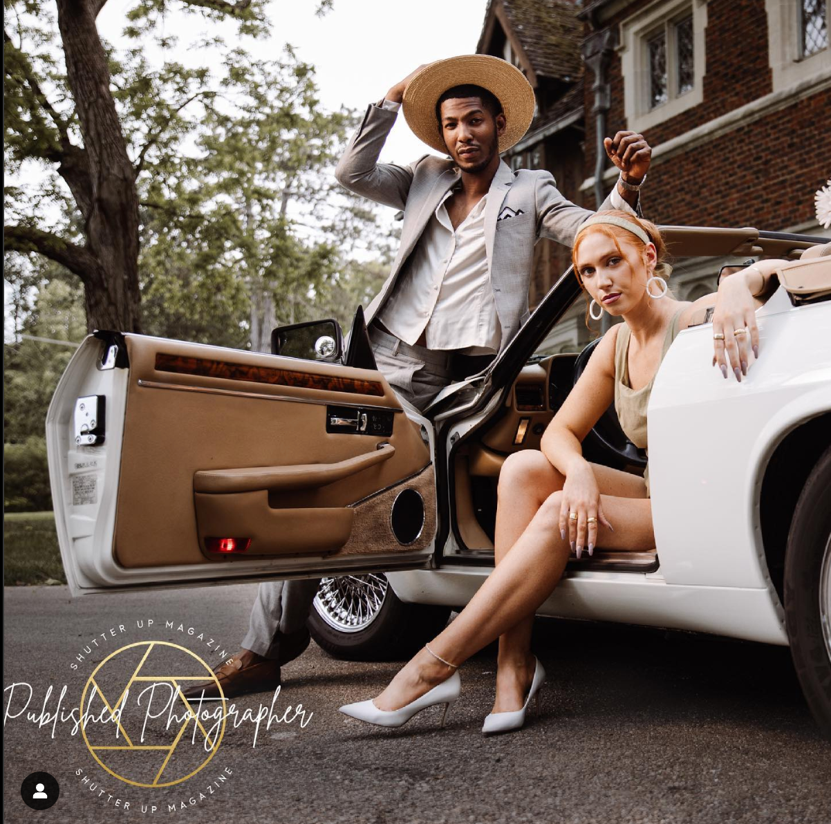 Lifestyle portrait of a couple posing with a classic white car.