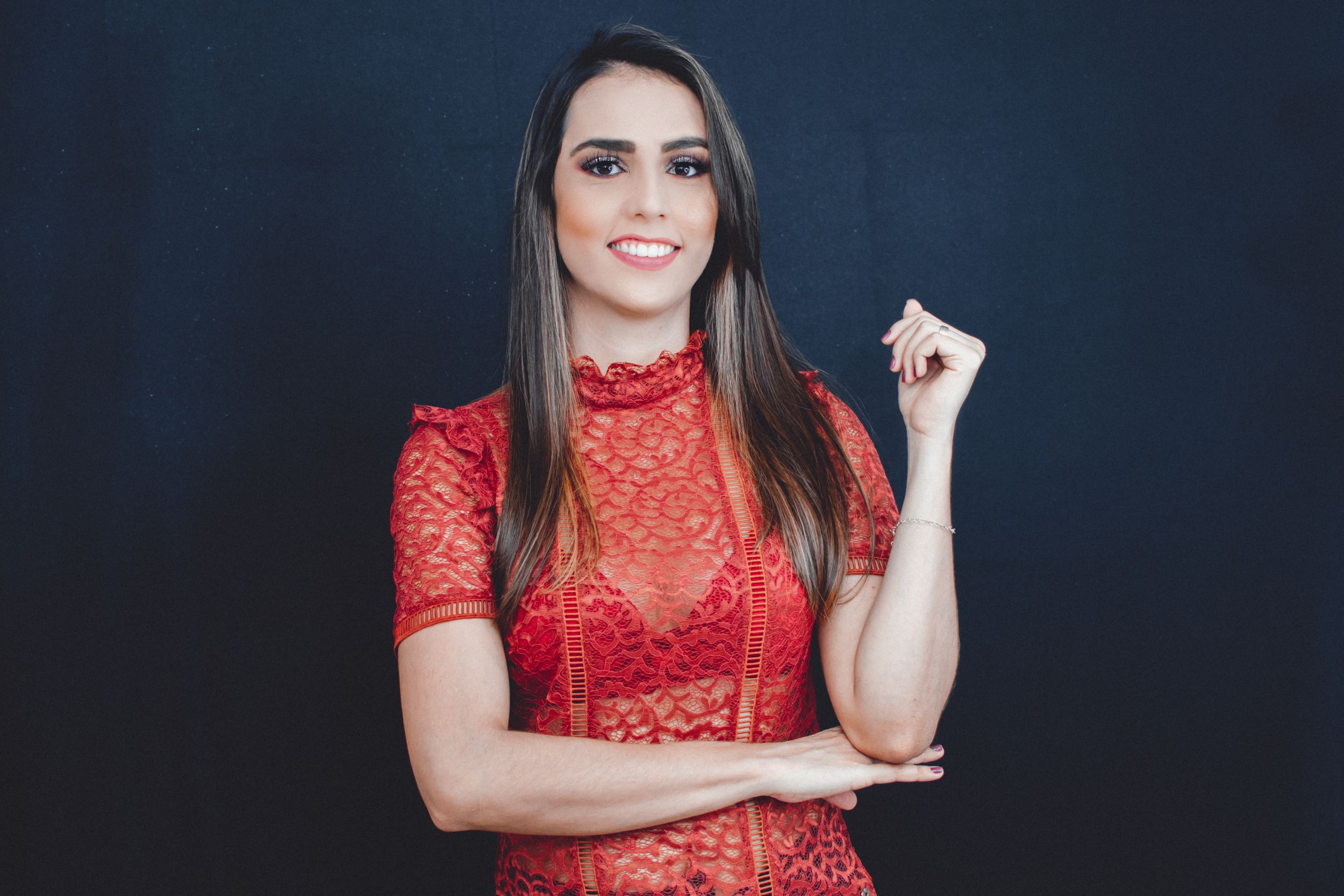 Studio portraits featuring red lace top and dark background with dramatic lighting.