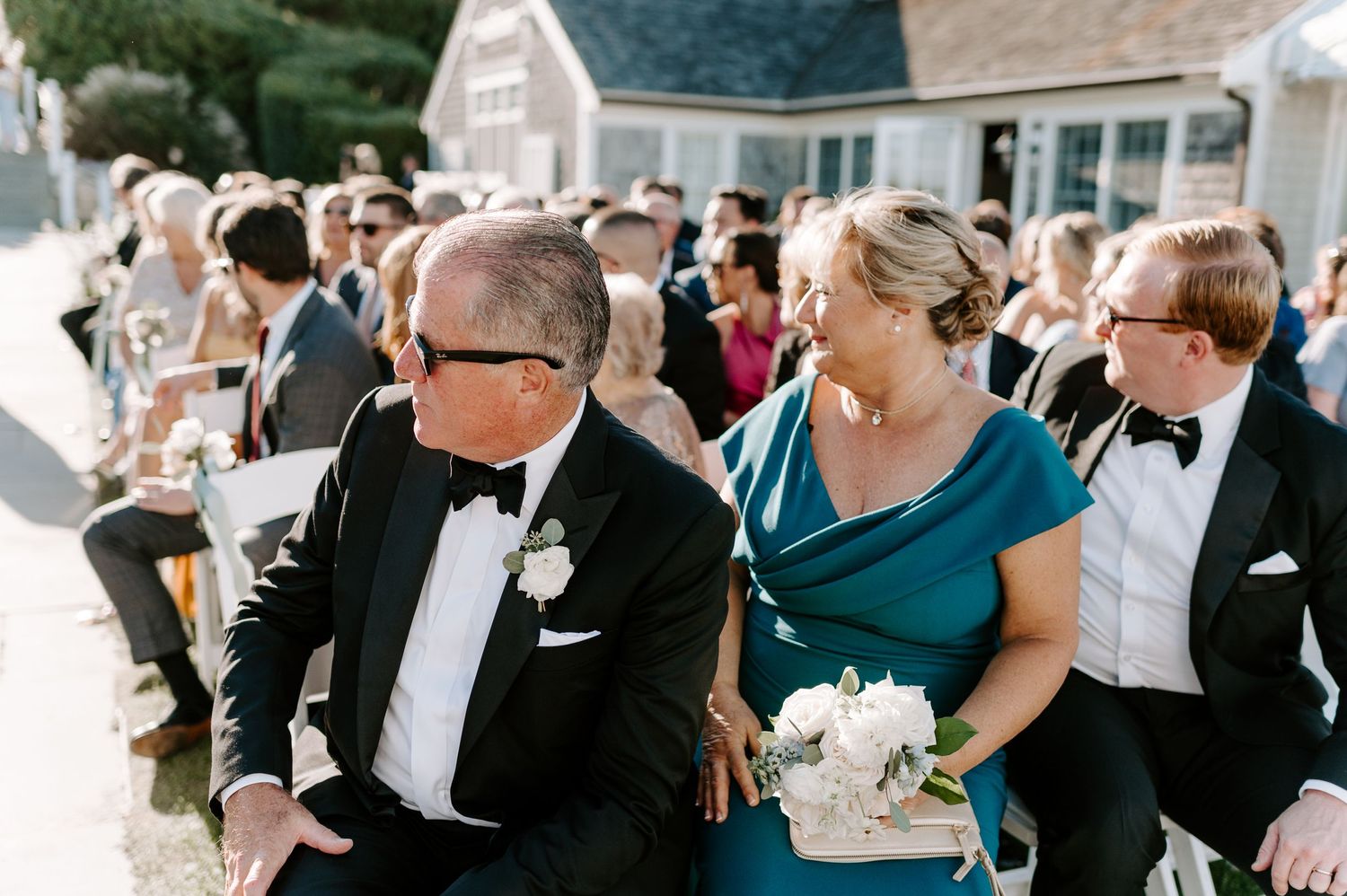 Wedding guests enjoying an outdoor celebration with drinks and laughter.
